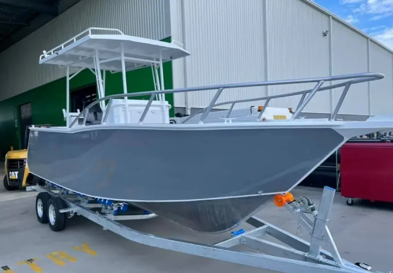 A boat is parked in the dock of an industrial area.